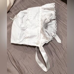 white baby bonnet with lace and ribbon trim